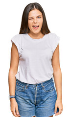 Fototapeta premium Young caucasian woman wearing casual white tshirt winking looking at the camera with sexy expression, cheerful and happy face.