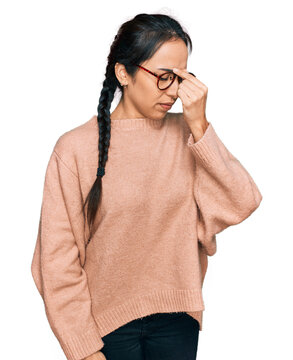 Young hispanic girl wearing casual clothes and glasses tired rubbing nose and eyes feeling fatigue and headache. stress and frustration concept.
