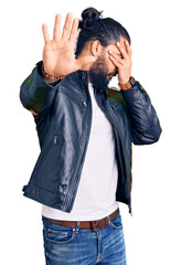 Young arab man wearing casual leather jacket covering eyes with hands and doing stop gesture with sad and fear expression. embarrassed and negative concept.