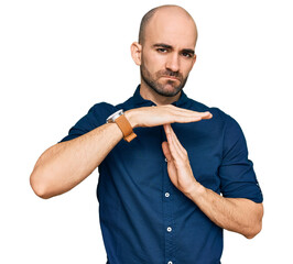 Young hispanic man wearing casual clothes doing time out gesture with hands, frustrated and serious...
