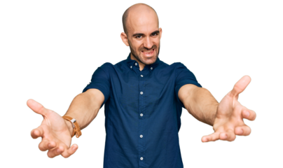 Young hispanic man wearing casual clothes looking at the camera smiling with open arms for hug. cheerful expression embracing happiness.