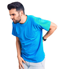 Obraz premium Young handsome man with beard wearing casual t-shirt suffering of backache, touching back with hand, muscular pain