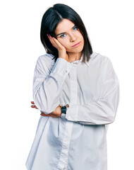 Young brunette woman with blue eyes wearing oversize white shirt thinking looking tired and bored with depression problems with crossed arms.