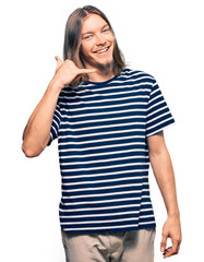 Handsome caucasian man with long hair wearing casual striped t-shirt smiling doing phone gesture with hand and fingers like talking on the telephone. communicating concepts.