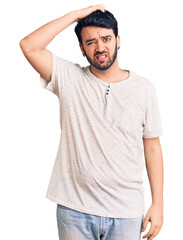 Fototapeta premium Young hispanic man wearing casual clothes confuse and wonder about question. uncertain with doubt, thinking with hand on head. pensive concept.