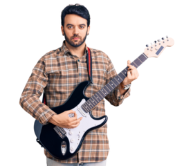Young hispanic man playing electric guitar thinking attitude and sober expression looking self confident