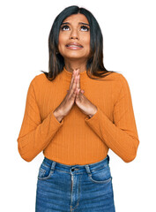 Young latin transsexual transgender woman wearing casual clothes begging and praying with hands...