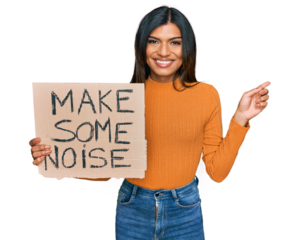 Young latin transsexual transgender woman holding make some noise banner smiling happy pointing with hand and finger to the side