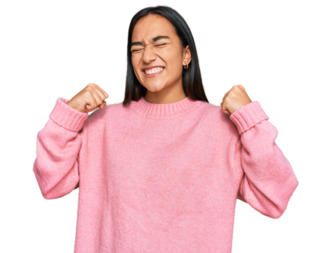 Young asian woman wearing casual winter sweater very happy and excited doing winner gesture with arms raised, smiling and screaming for success. celebration concept.
