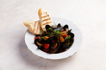 Cooked mussels and toasted bread in a plate.