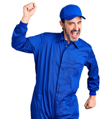Middle age handsome man wearing mechanic uniform dancing happy and cheerful, smiling moving casual and confident listening to music