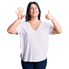 Young beautiful brunette woman wearing casual t-shirt showing and pointing up with fingers number six while smiling confident and happy.