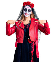 Woman wearing day of the dead costume over background looking confident with smile on face,...