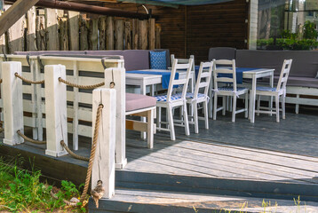 White wood furniture in the kitchen. Wooden furniture on the terrace of the house in summer. Rest...