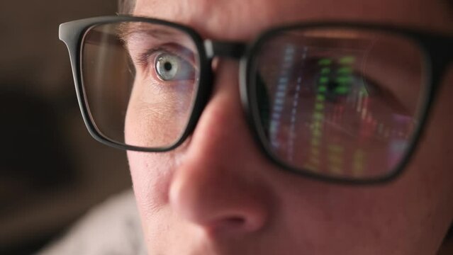 Online trading stock market data chart in office room with light reflection on eyeglasses surface, close up face of caucasian female crypto Trader looking at computer screen while analyzing 
