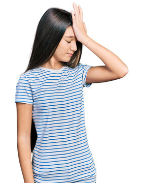 Young brunette girl with long hair wearing casual striped t shirt surprised with hand on head for mistake, remember error. forgot, bad memory concept.