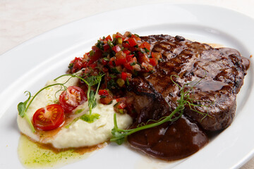 T-bone steak and mashed potatoes in a plate.