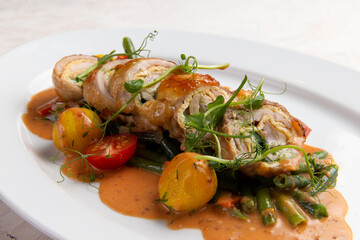 Chicken roll and new potatoes in a plate.