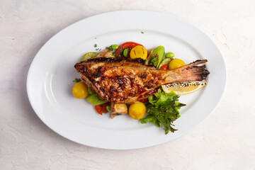 Grilled perch in a bowl. On a light background.
