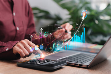 Financial investment analysis and marketing development concepts, Business women use calculator and laptop analysis graph of marketing data on a virtual screen business effectively grown