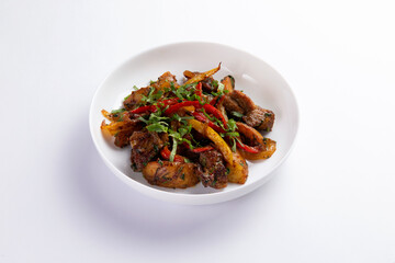 Fried meat with potatoes and vegetables in a plate.