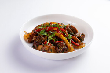 Fried meat with potatoes and vegetables in a plate.