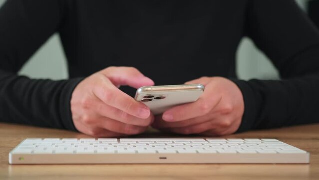 Close-up female hands holding a smartphone and quickly typing with thumbs on the phone screen flipping through the tape. Modern wireless tech user concept.