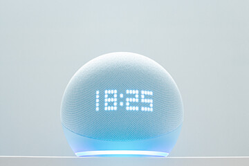 echo dot voice controlled speaker with blue neon activated voice recognition, on white background.