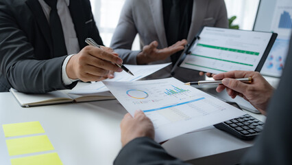 Group of business people working together on new project with planning analytical report at meeting. Businesspeople meeting together pointing to graph assess business profits.