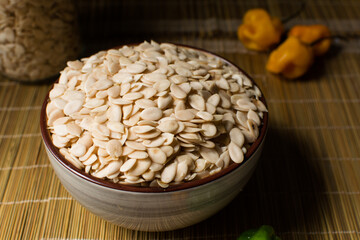 nigerian egusi seeds in a brown bowl, shelled melon seeds in a bowl, nigerian melon seeds, pumpkin seeds for cooking