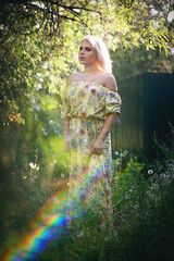 Beautiful young girl in the green willow tree branches portrait.