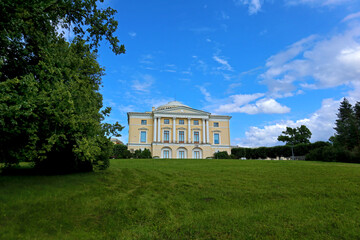 Beautiful park next to royal palace of the Russian Emperor Paul 1 and his family. Summer view of architecture of the Imperial residence and scenic landscape in Pavlovsk near St. Petersburg, Russia.
