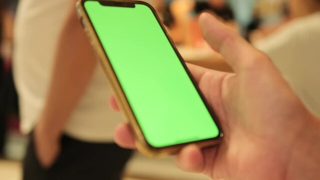 Female hand scrolls the social media feed in a smartphone, chromakey, close up. Internet purchase, browse web, download new cool freeware application.