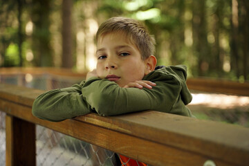 Portrait of a cute boy in a hoodie in nature in summer.