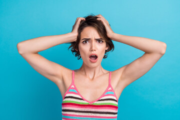 Photo of impressed puzzled woman dressed striped tank top arms head open mouth isolated blue color background
