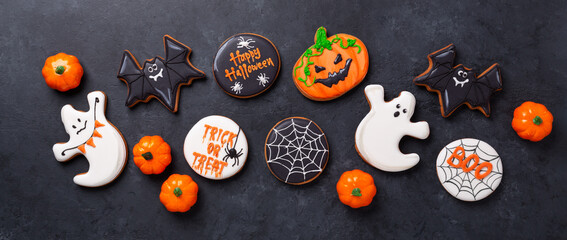 Halloween banner with gingerbread cookies on dark stone background. Bright homemade cookies for...