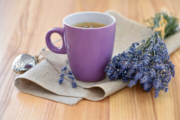 Cup of tea and lavender flowers on a wooden table