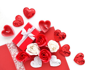 Valentines Day background. Red gift box with roses, ribbon and hearts on white and red background. Top view. Greeting card.