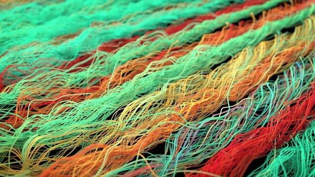 Closeup on colorful threads of fabric, long twisted filaments arranged close to each other, camera moves to the side showing many colors of tangled lines. 