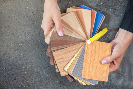 laminate samples. The choice of laminated surface for chipboard. Samples of wood imitation laminate in hands, close-up.