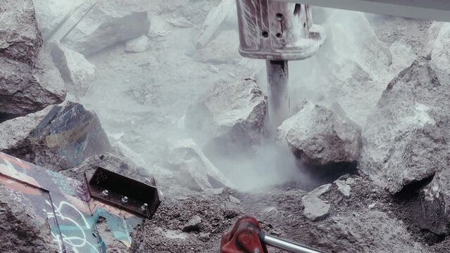 Close-ups of hydraulic rock breakers crushing bridge debris. This 4K footage embodies infrastructure repair, spotlighting the raw force that reshapes our built environment