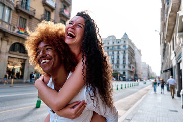 couple of tourists doing piggyback in Barcelona, Spain - obrazy, fototapety, plakaty