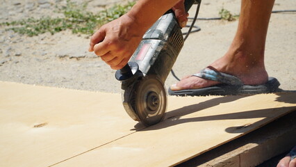 Carpentry works. A carpenter cuts an OSB board with an electric jigsaw. Wood sawing. Construction.