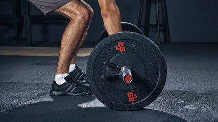 Power, fitness of a man with barbell weight lift exercise, workout or training in gym. Closeup...