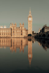 Tower of Big Ben in London, with its reflection in the River Thames. On a sunny day.