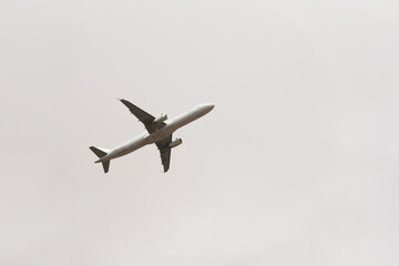 Airplane flying in the sky, bottom view. Commercial plane taking off