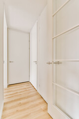 an empty room with white walls and wood flooring the door is open on the right, there are two closets