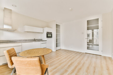 an empty kitchen and dining area in a modern apartment with white walls, hardwood flooring and light wood floors