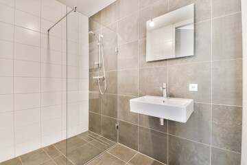 a bathroom with a sink, mirror and shower head mounted on the wall next to a walk - in shower