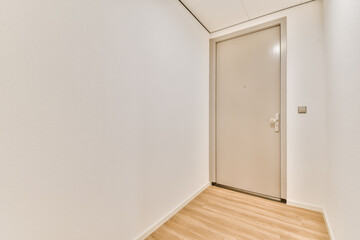 an empty room with white walls and wood flooring the door is open in front of the wall there is a wooden floor